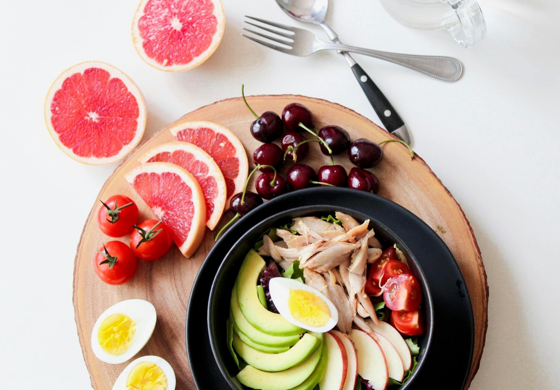 bowl of vegetable salad and sliced fruits